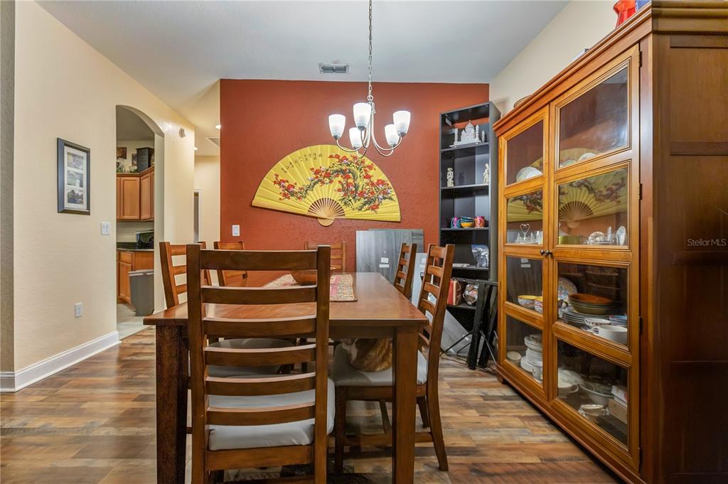 A dining room features a wooden table, chairs, a large wall fan, and a china cabinet — 2818 WHITNEY STREET, LAKELAND, FL