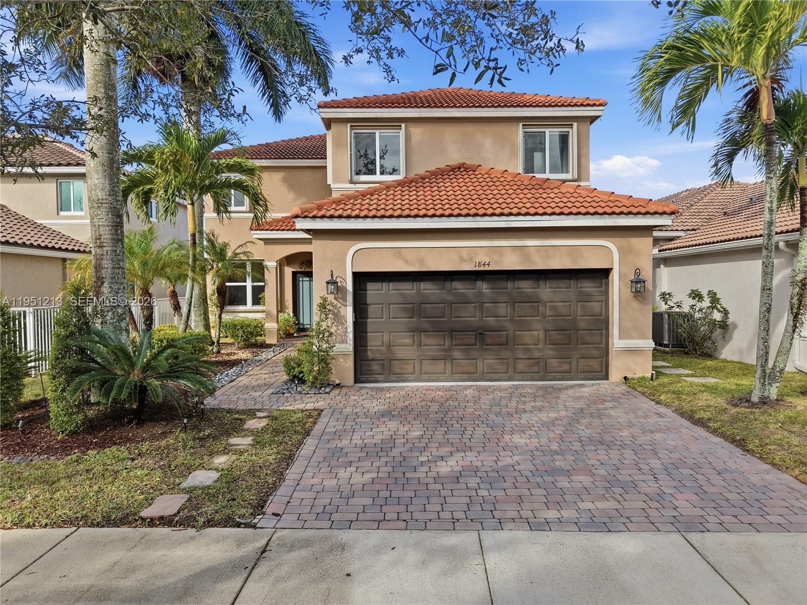 A two-story house with a brown garage door, tiled roof, and a paved driveway — 1844 Aspen Ln, Weston FL 33327, WESTON, FL