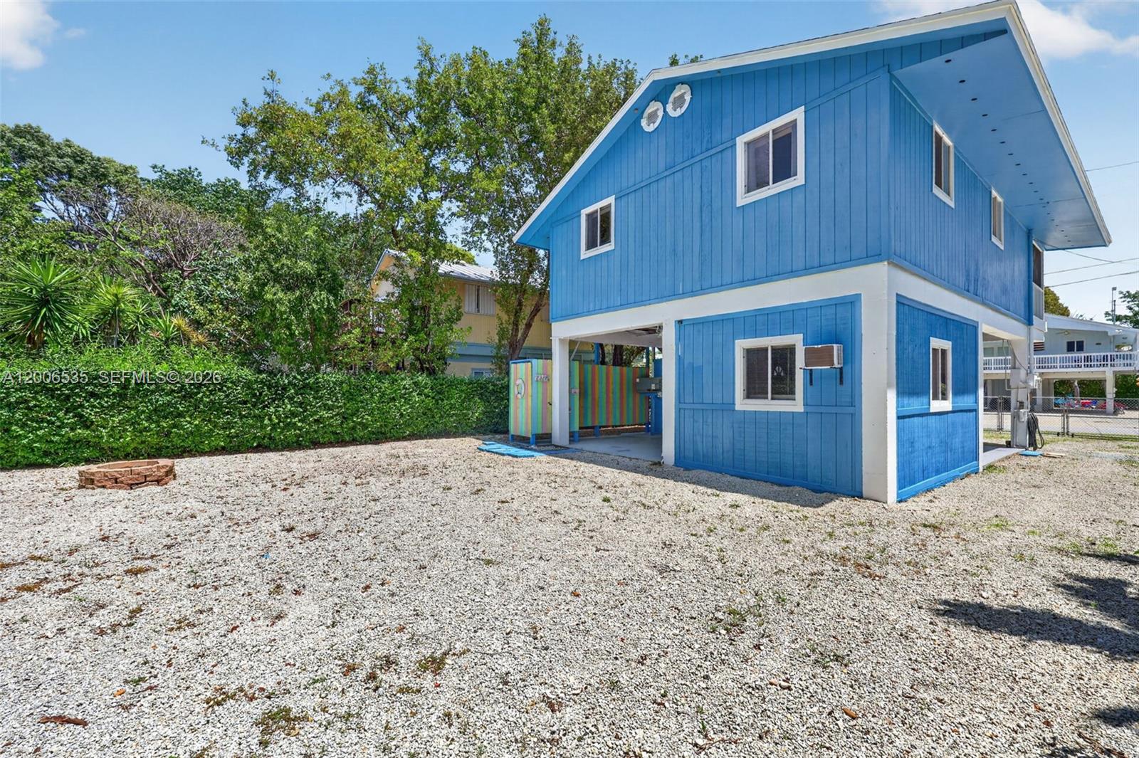 A blue two-story house with a gravel yard and a small fire pit — 414 Mahogany Ave, Key Largo FL 33037, KEY LARGO, FL