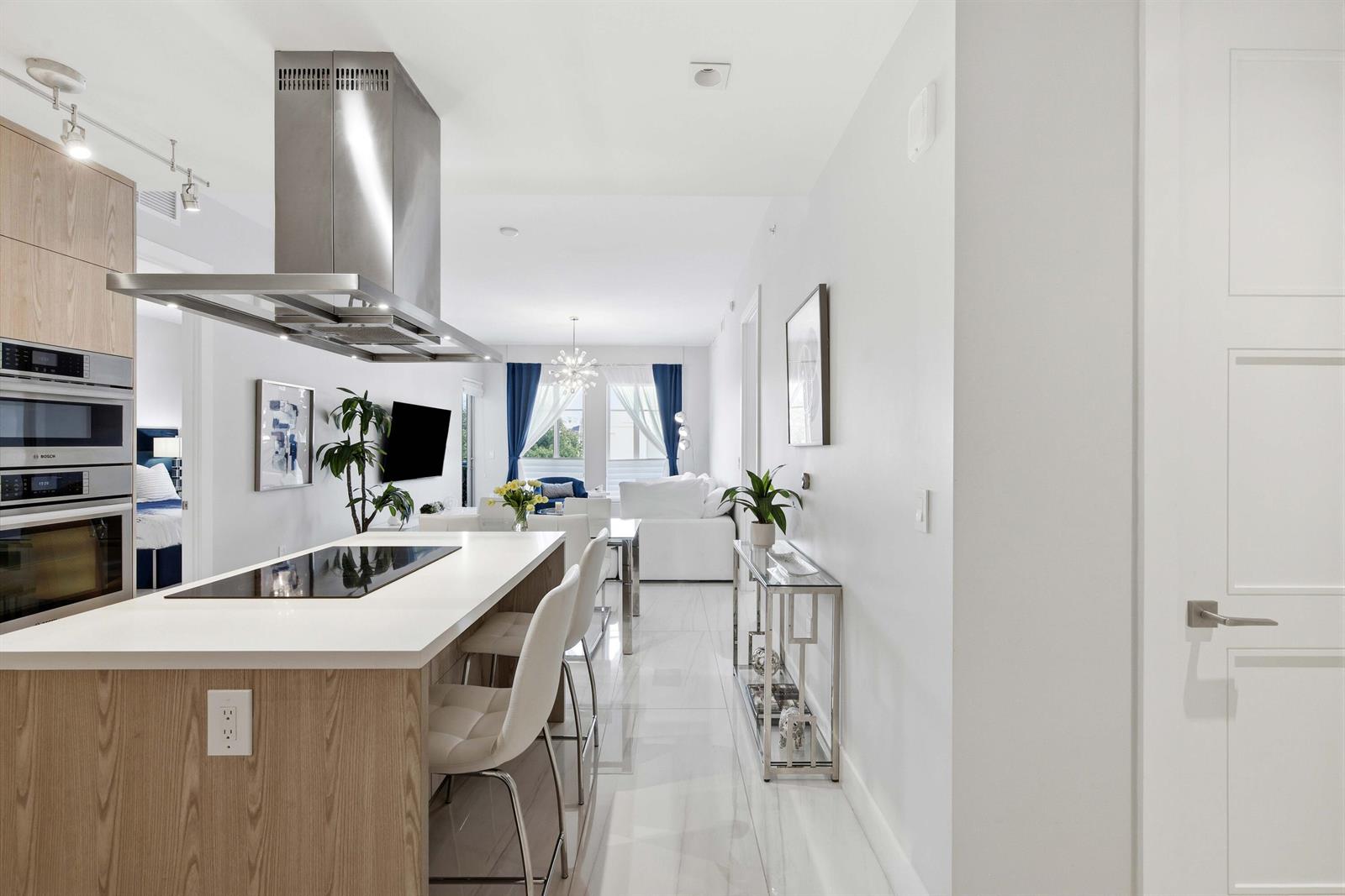 A modern kitchen with a white island and stainless steel appliances opens into a living area — 155 E Boca Raton Road # 313, Boca Raton FL 33432, BOCA RATON, FL
