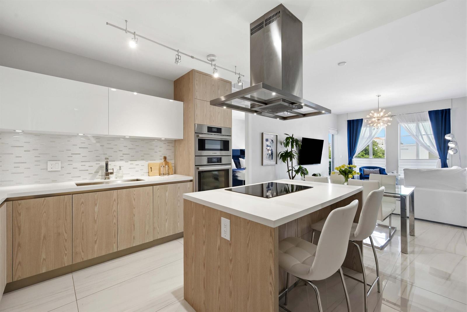 A modern kitchen features light wood cabinets, white countertops, a center island, and stainless appliances — 155 E Boca Raton Road # 313, Boca Raton FL 33432, BOCA RATON, FL