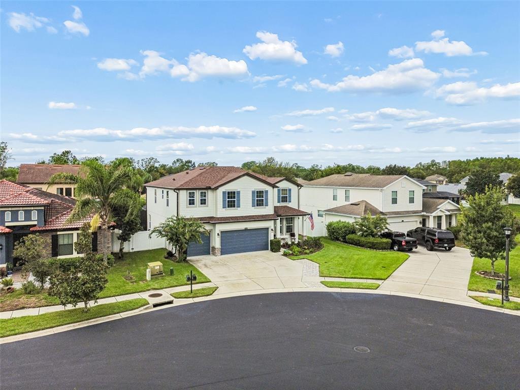 An aerial view shows two-story houses with driveways and lawns on a suburban cul-de-sac — 23958 TERRACINA COURT, LAND O LAKES, FL