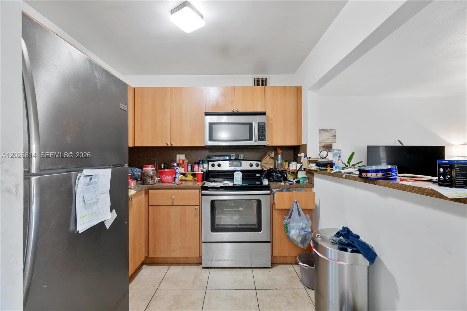 A bedroom features white walls, tile flooring, a bed with gray bedding, and vertical blinds — 9445 SW 76th St # U4, Miami FL 33173, MIAMI, FL