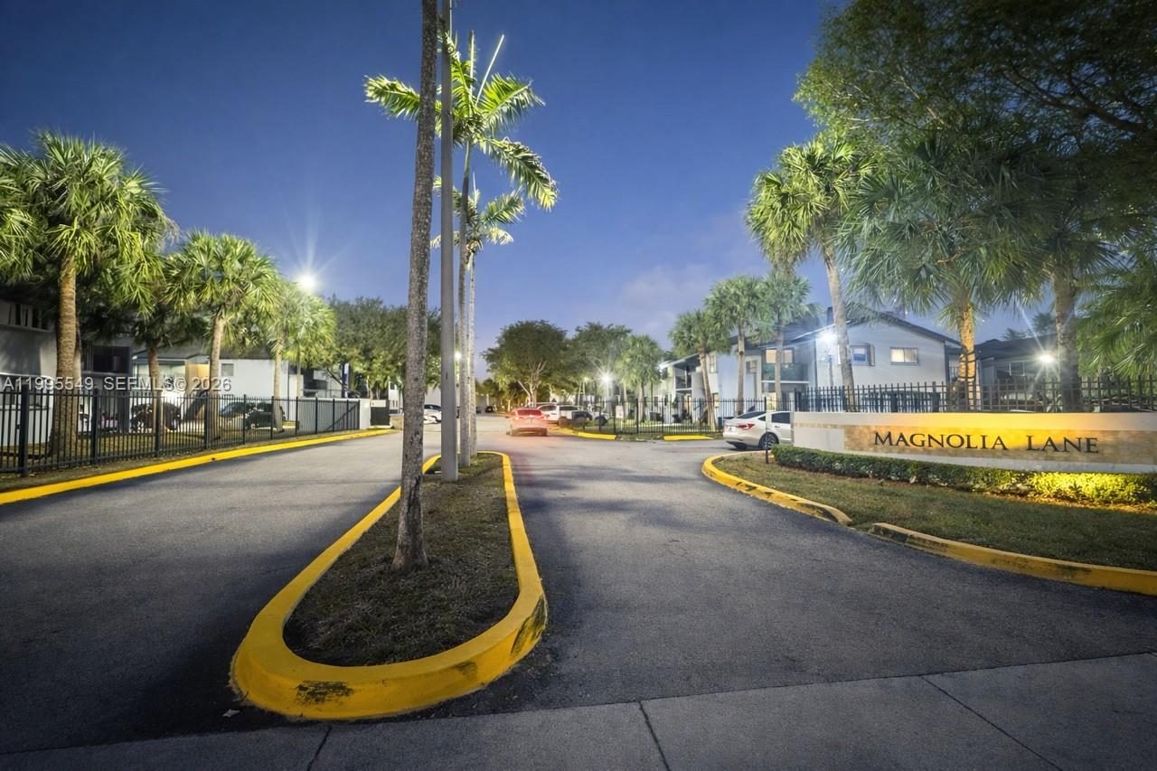 The entrance to the Magnolia Lane residential complex features palm trees and a paved driveway — 7423 SW 152ND AVE # 103, Miami FL 33193, MIAMI, FL