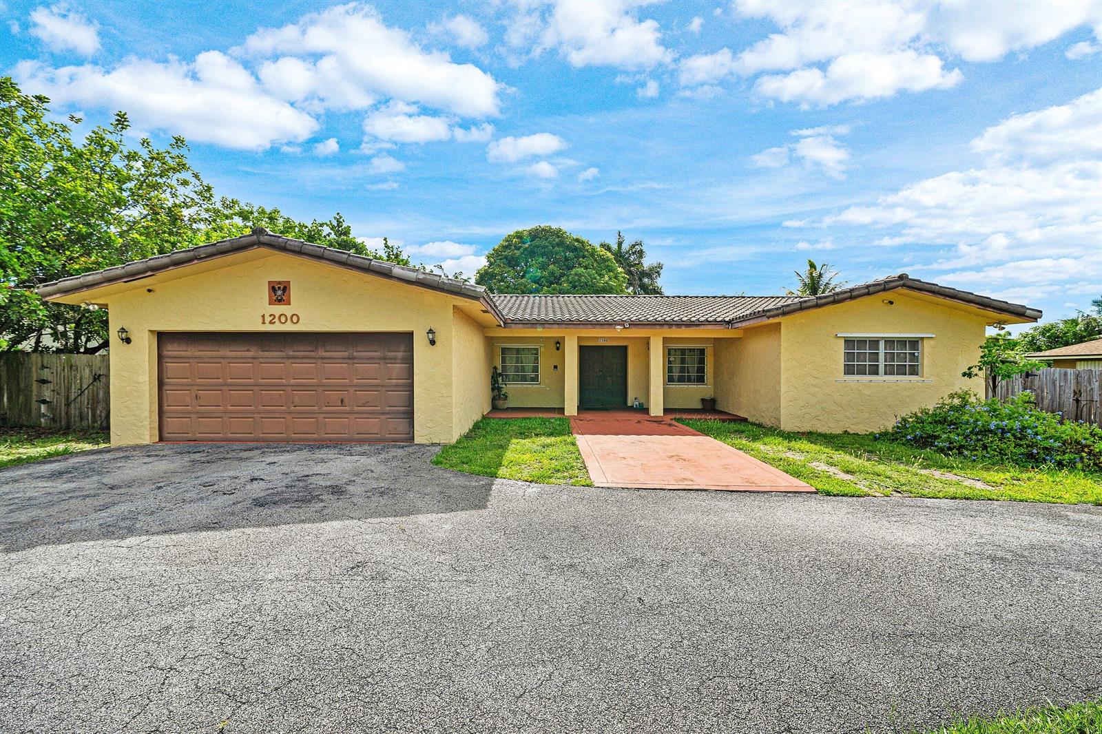 A single-story yellow house with a two-car garage and a tiled roof — 1200 NW 4TH Avenue, Boca Raton FL 33432, BOCA RATON, FL