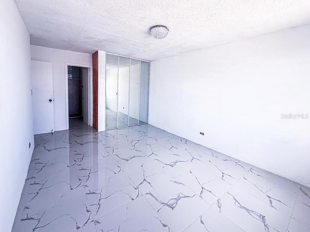A room with white walls, a textured ceiling, and light-colored marble-patterned tile flooring — MIRAMAR TOWERS 721 HERNANDEZ ST. UNIT A, SAN JUAN, PR