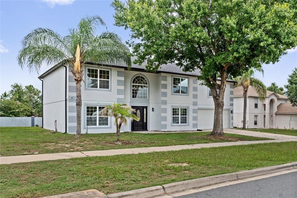 A two-story house with light gray stucco walls, white trim, and a front-facing garage — 2960 WHITE MAGNOLIA LOOP, CLERMONT, FL