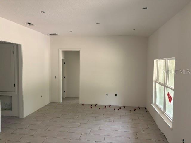 An interior view of a room with light-colored tile flooring, white walls, and recessed lighting — 7744 SW 180TH CIRCLE, DUNNELLON, FL