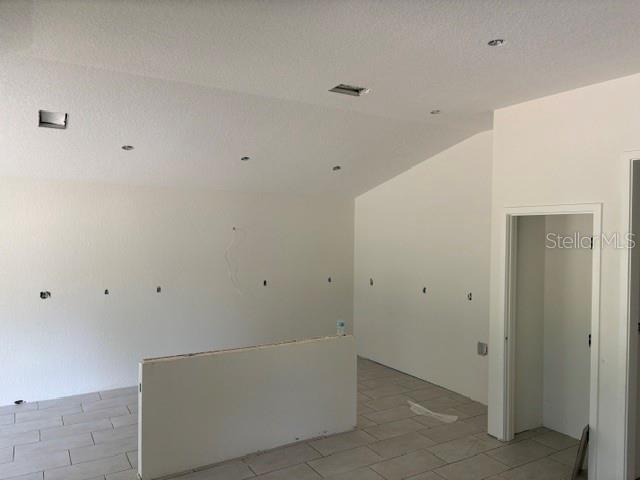 An unfinished room with white walls, recessed lighting, and light-colored tile flooring — 7744 SW 180TH CIRCLE, DUNNELLON, FL