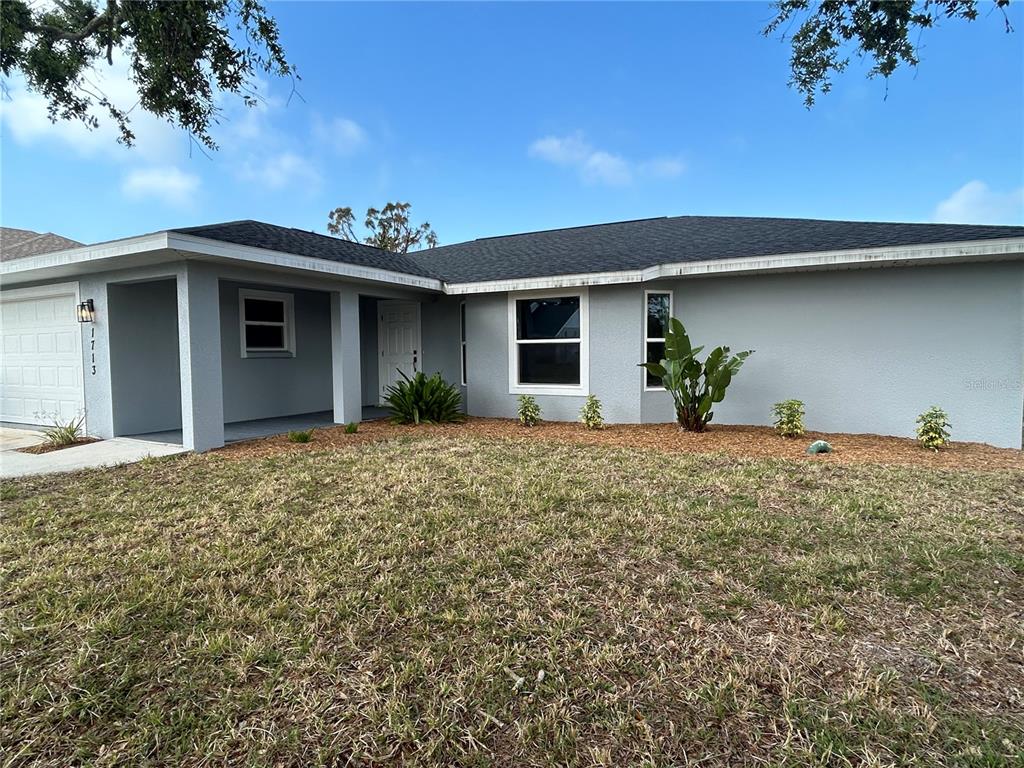 A single-story gray house with a dark shingled roof and a covered front entryway — 1713 WALDEN COURT, ENGLEWOOD, FL