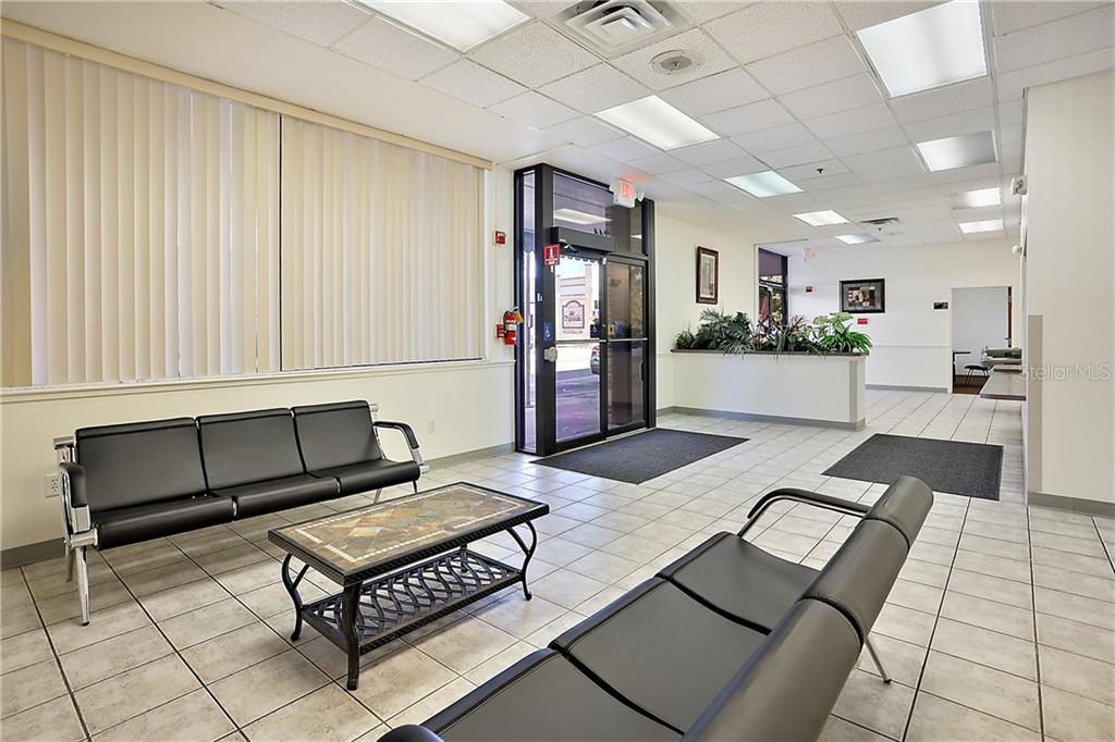 A waiting room features black seating, a tile floor, and large windows with vertical blinds — 711 W MAIN STREET, LEESBURG, FL
