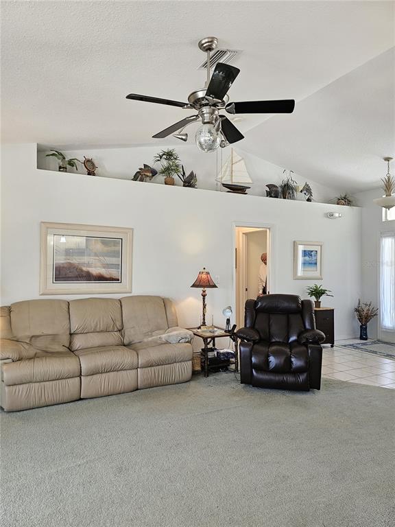 A living room features a vaulted ceiling, a ceiling fan, and a beige sofa — 15001 APPLETON BLVD, PORT CHARLOTTE, FL