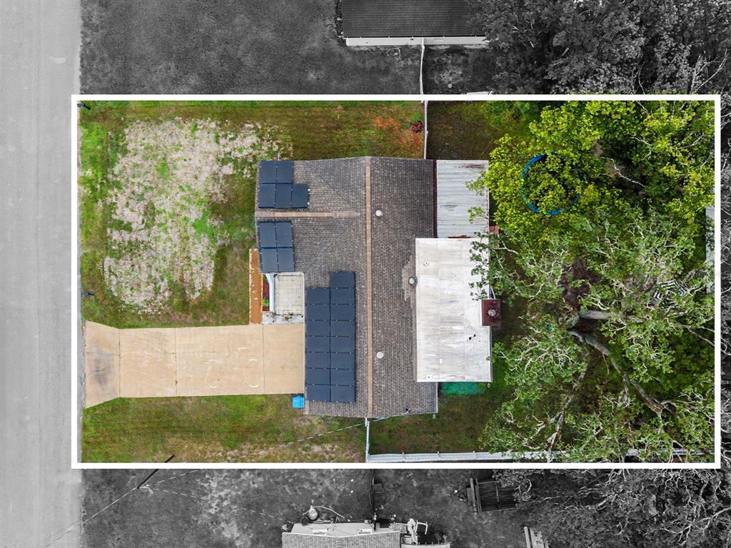 An aerial view shows a house with solar panels on the roof and a large tree — 197 ROSEDALE AVENUE, SPRING HILL, FL