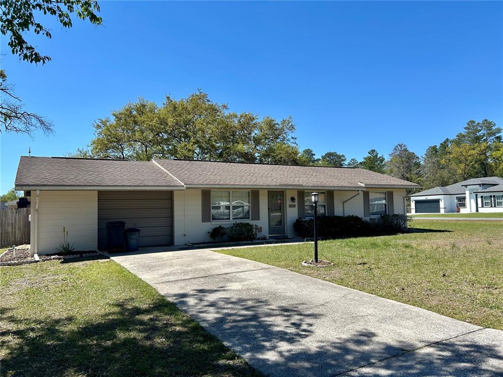 A single-story house with a beige exterior, a garage, and a concrete driveway — 14152 SW 42ND TERRACE ROAD, OCALA, FL