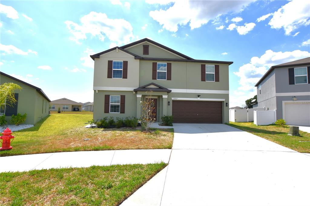 A two-story house with green siding, brown shutters, and a two-car garage — 2767 RED EGRET DRIVE, BARTOW, FL