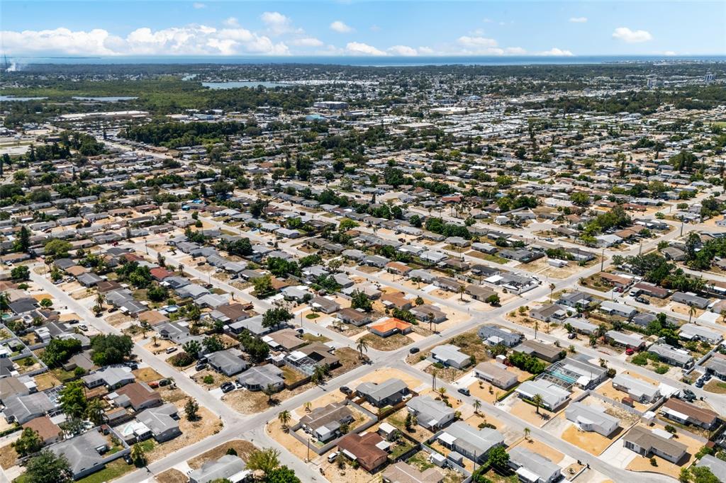 An aerial view shows a dense residential neighborhood with many single-story houses and paved streets — 1118 EXCALIBUR STREET, HOLIDAY, FL