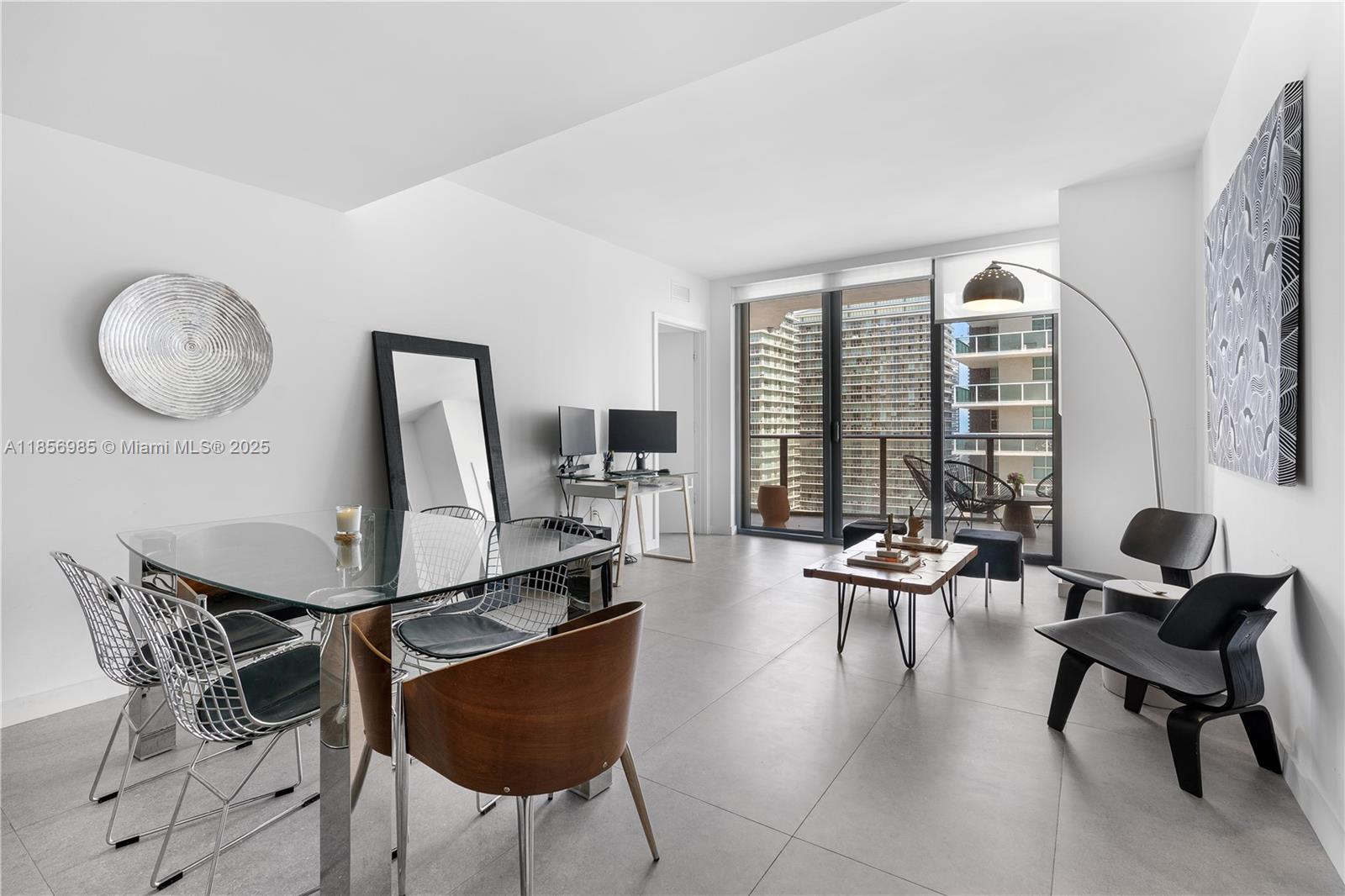 A modern living and dining area features tile floors, glass furniture, and a balcony view — 1300 S Miami Ave # 2411, Miami FL 33130, MIAMI, FL