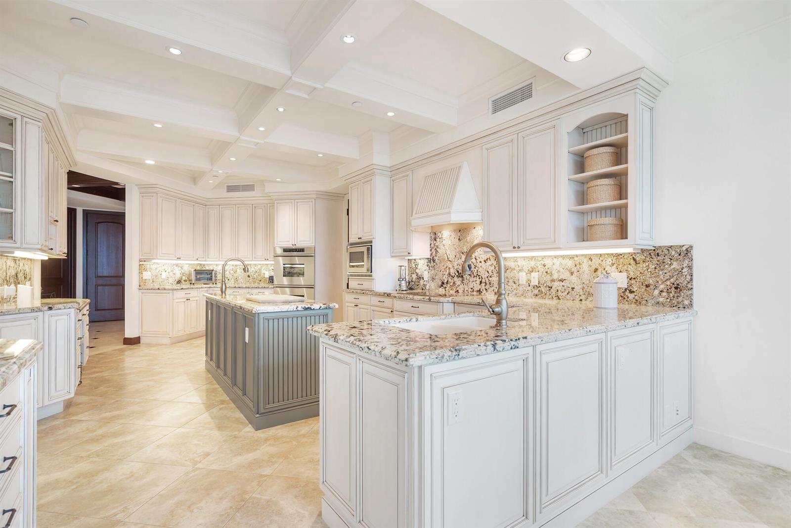 A kitchen features white cabinetry, granite countertops, a gray island, and a coffered ceiling — 120 Jupiter Key Road # 4, Jupiter FL 33477, JUPITER, FL