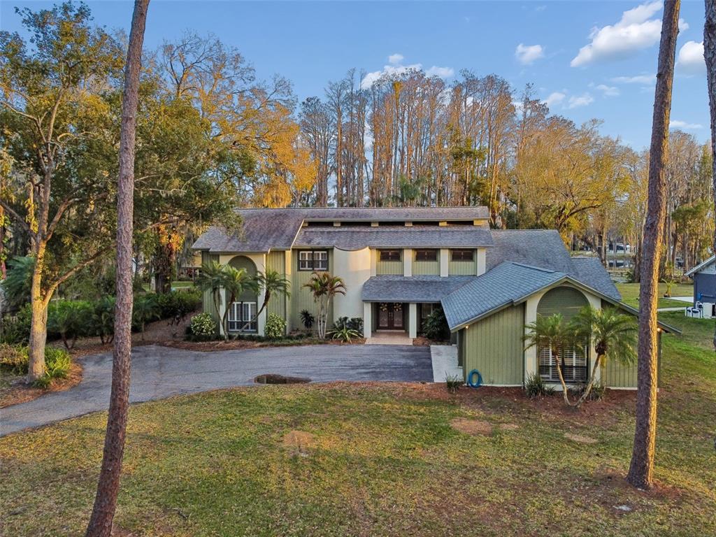 A two-story house with green siding and a gray shingled roof sits on a lot — 3812 LITTLE ROAD, LUTZ, FL
