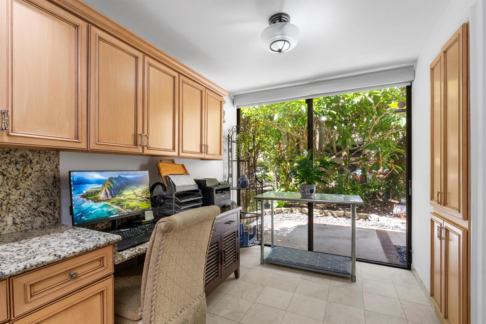 A home office features light wood cabinetry, granite countertops, and a sliding glass door to greenery — 793 Saint Albans Drive, Boca Raton FL 33486, BOCA RATON, FL