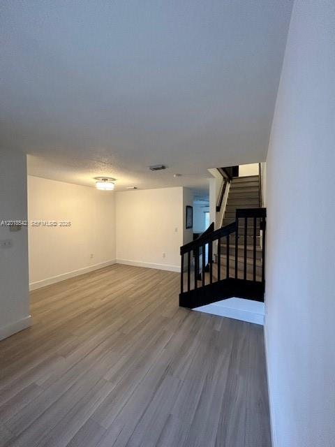 An interior view shows a living area with light wood flooring and a staircase — 13884 SW 64th St, Miami FL 33183, MIAMI, FL