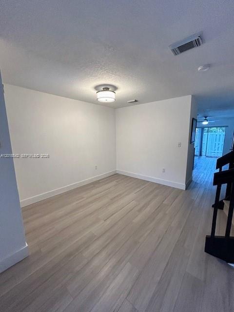 An empty room features light wood-look flooring, white walls, and a central ceiling light fixture — 13884 SW 64th St, Miami FL 33183, MIAMI, FL