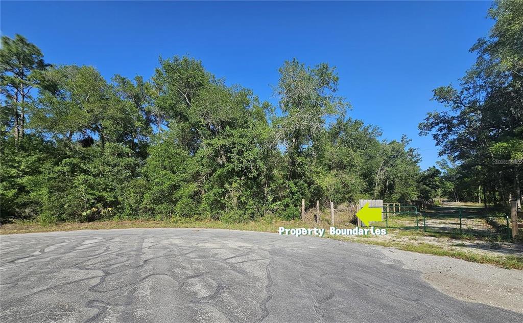A paved cul-de-sac leads to a wooded lot with a gated entrance and fencing — 13431 FLAGSTAFF DRIVE, BROOKSVILLE, FL