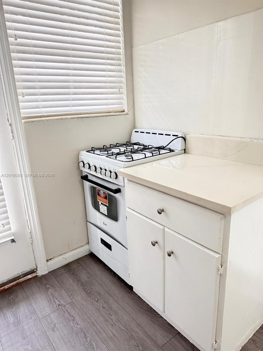A white gas stove sits next to a white cabinet with a countertop in a kitchen — 1007 Meridian Ave # 9, Miami Beach FL 33139, MIAMI BEACH, FL