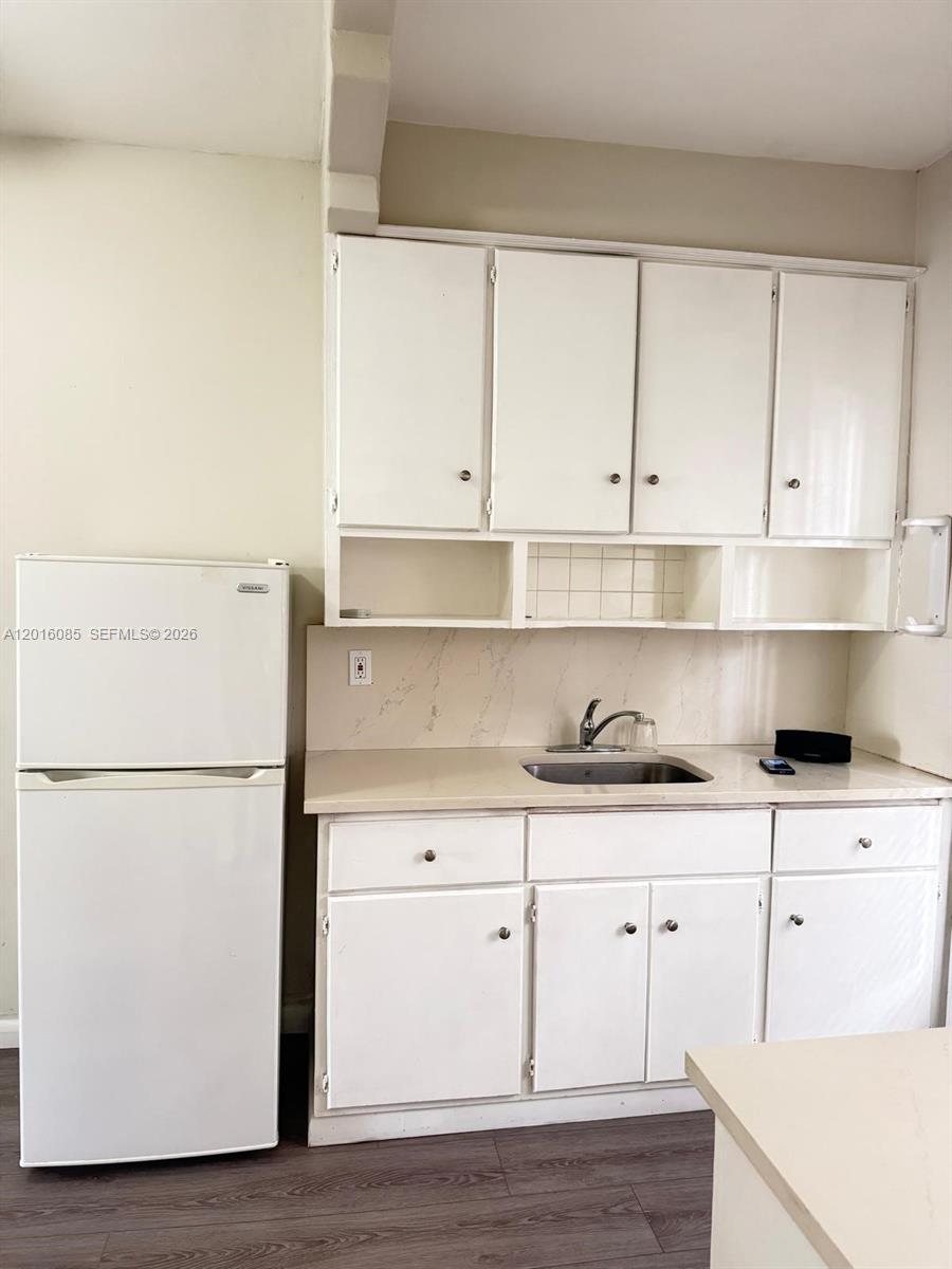 A small kitchenette features white cabinets, a stainless steel sink, and a white refrigerator — 1007 Meridian Ave # 9, Miami Beach FL 33139, MIAMI BEACH, FL
