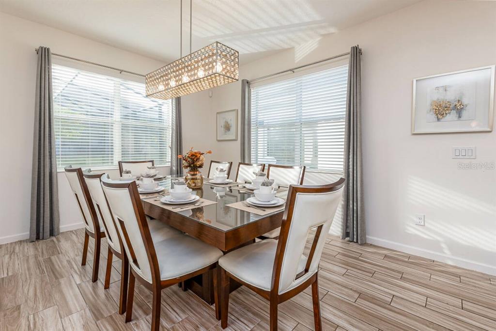 A dining room features a glass-topped table, six chairs, and a rectangular crystal chandelier — 2678 CALISTOGA AVENUE, KISSIMMEE, FL