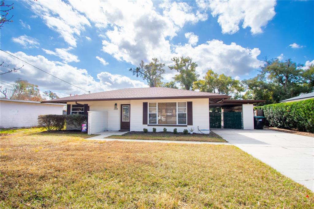 A single-story house with white siding, a brown roof, and a concrete driveway — 2818 E MICHIGAN STREET, ORLANDO, FL
