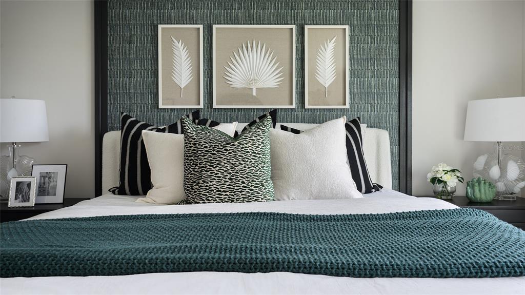A bedroom features a textured teal accent wall, framed botanical art, and a knitted throw — 2119 LAWSON WAY, ZEPHYRHILLS, FL