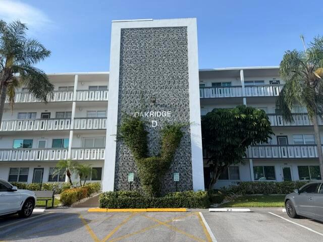 A three-story apartment building with a textured gray facade labeled Oakridge D — 2026 Oakridge D, Deerfield Beach FL 33442, DEERFIELD BEACH, FL