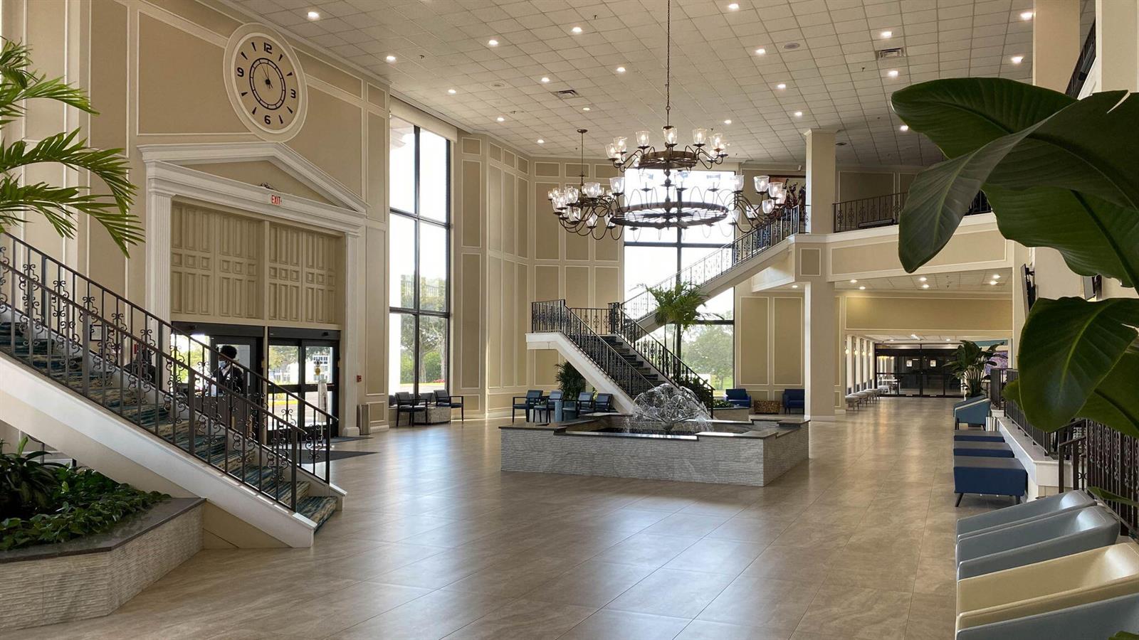 A spacious hotel lobby features a grand staircase, a central fountain, and a large clock — 2026 Oakridge D, Deerfield Beach FL 33442, DEERFIELD BEACH, FL