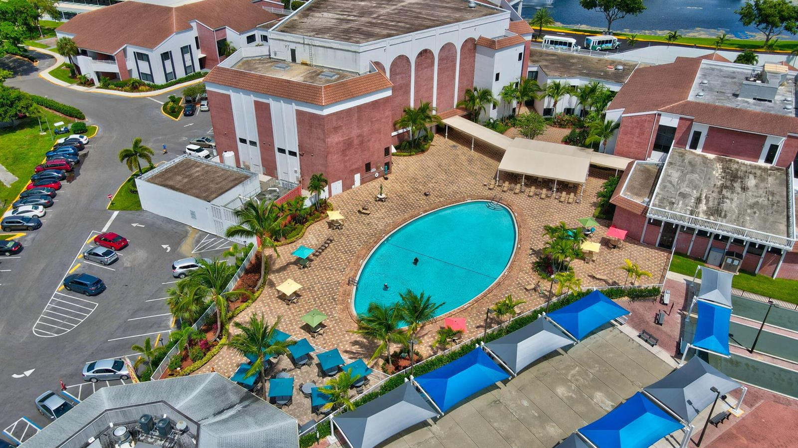 An aerial view of a brick building complex featuring a large oval swimming pool — 2026 Oakridge D, Deerfield Beach FL 33442, DEERFIELD BEACH, FL
