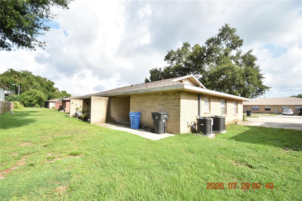 A single-story brick building with a covered patio, two trash bins, and two AC units — 411 BIG CEDAR WAY UNIT A, BRANDON, FL