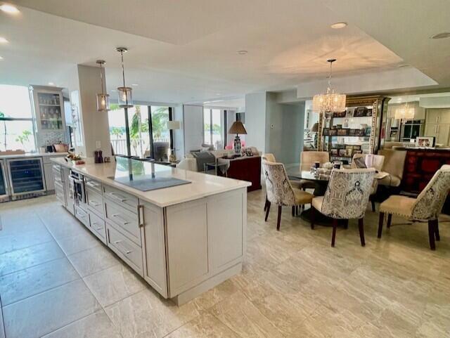 A kitchen with a large island and dining area features light cabinetry and tile floors — 2860 S Ocean Boulevard # 301, Palm Beach FL 33480, PALM BEACH, FL