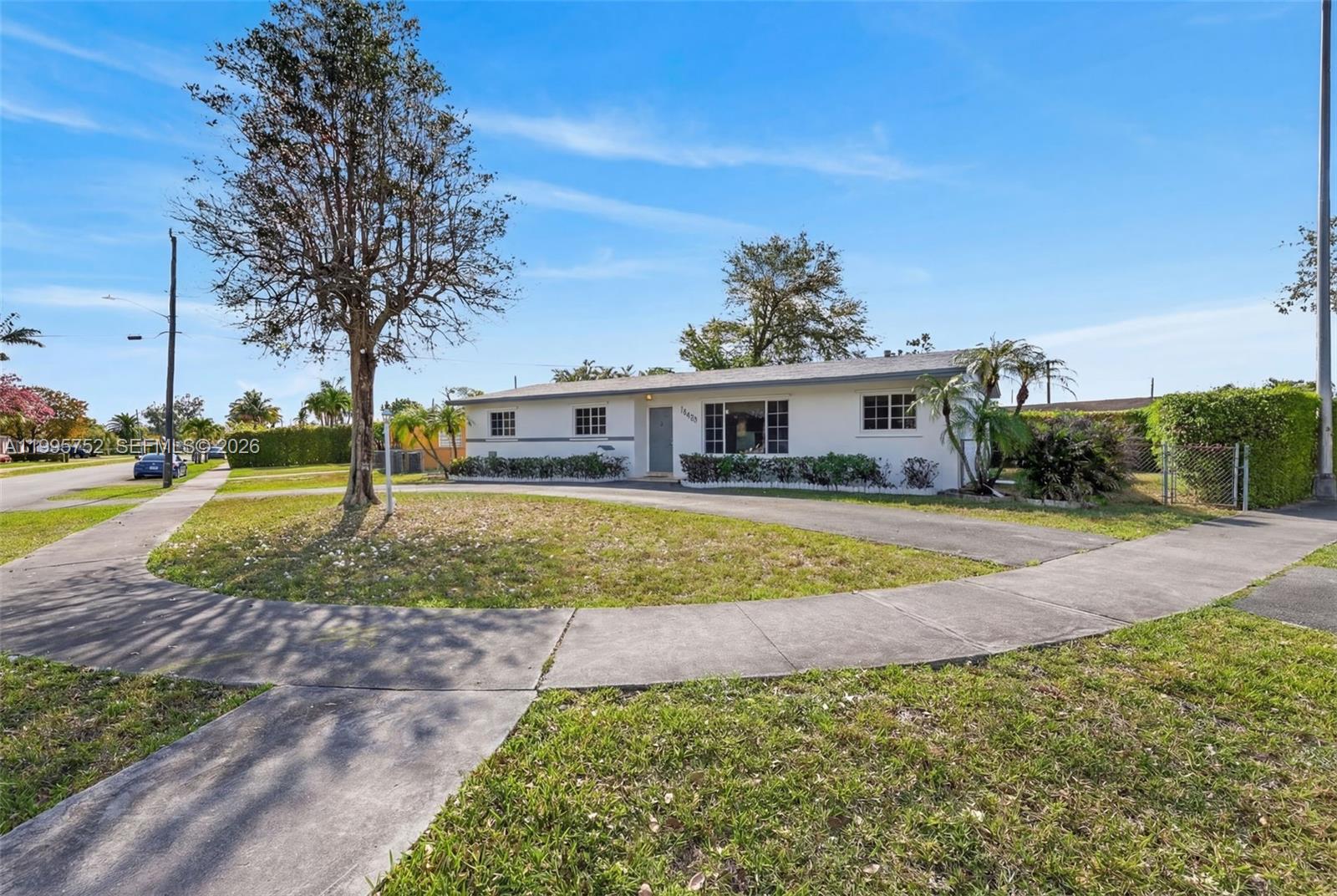 A single-story white house with a driveway and a large tree in the front yard — 11190 SW 57th St, Miami FL 33173, MIAMI, FL