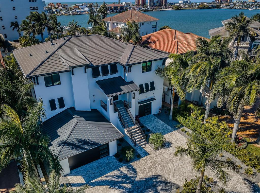 An aerial view of a modern white house with a dark metal roof and palm trees — 218 SYDNEY LANE, REDINGTON SHORES, FL