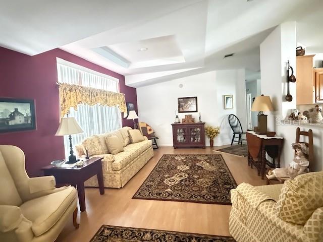 A living room features a beige sofa, patterned rugs, and a dark wood side table — 197 PHILADELPHIA BOULEVARD UNIT 26, PALM HARBOR, FL
