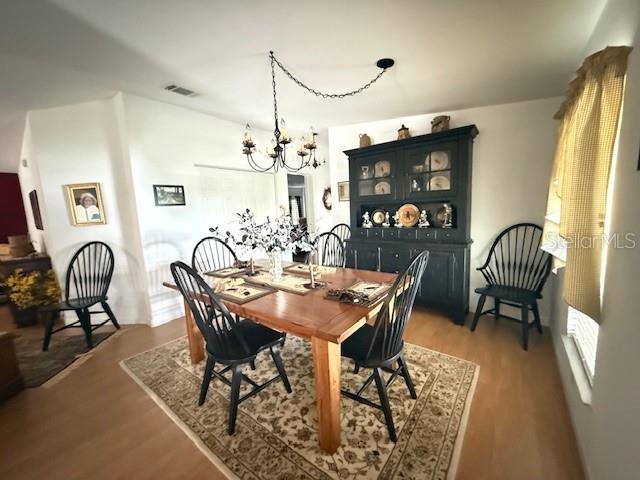 A dining room features a wooden table, black spindle chairs, and a dark hutch — 197 PHILADELPHIA BOULEVARD UNIT 26, PALM HARBOR, FL