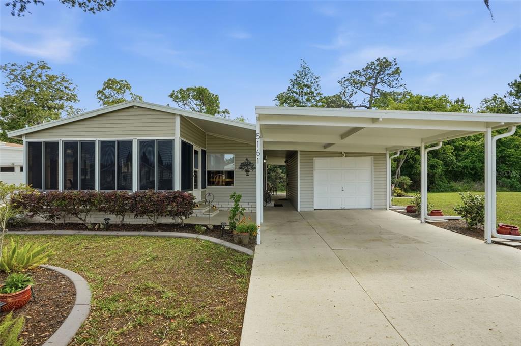 A single-story house with a screened-in porch, a concrete driveway, and an attached carport — 5161 FOREST GLENN DRIVE, SPRING HILL, FL