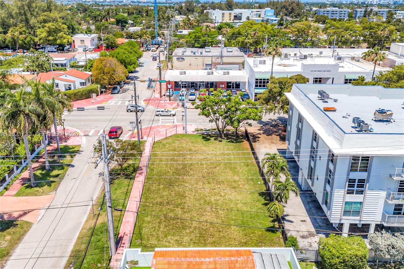 An aerial view shows a vacant rectangular grass lot adjacent to a multi-story apartment building — 1240 71st St, Miami Beach FL 33141, MIAMI BEACH, FL