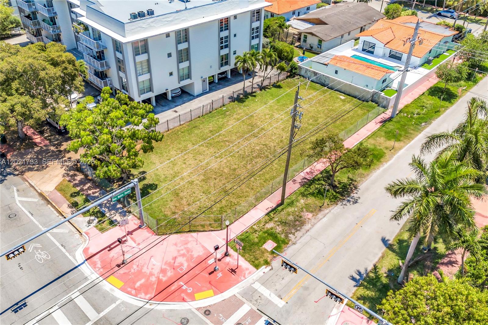 An aerial view shows a vacant, fenced grassy lot situated between a building and street — 1240 71st St, Miami Beach FL 33141, MIAMI BEACH, FL