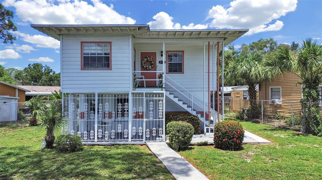 A two-story white house with a metal-caged ground floor and an exterior staircase — 2371 7TH STREET S, ST PETERSBURG, FL