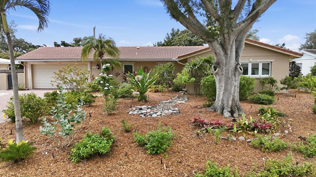 A single-story house with a tiled roof and a landscaped front yard featuring mulch — 3504 BROOKLINE DRIVE, SARASOTA, FL