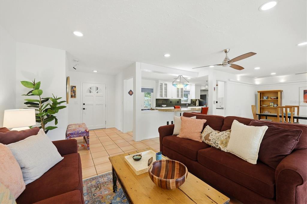 A living room with dark red sofas, a wooden coffee table, and an open kitchen — 3504 BROOKLINE DRIVE, SARASOTA, FL