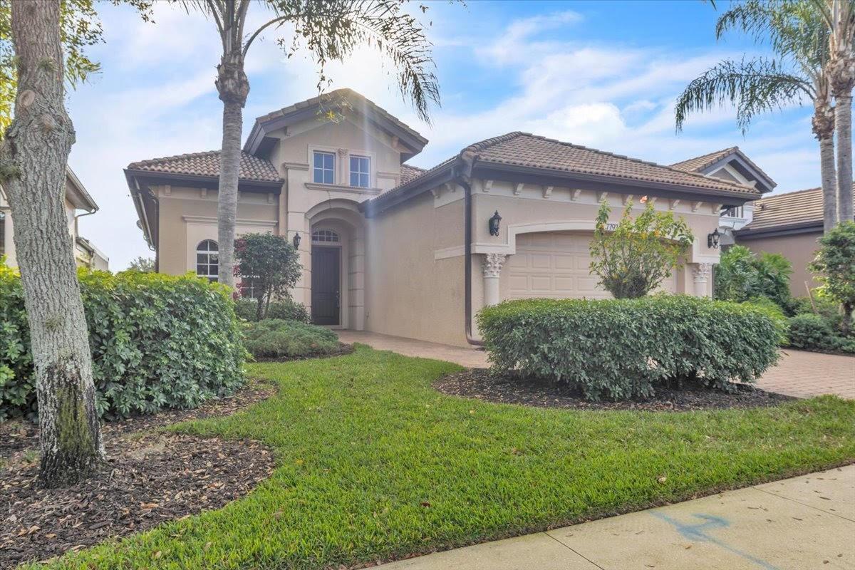 A single-story suburban house with a tan stucco exterior, tile roof, and front-facing garage — 7793 Ashton Road, Naples FL 34113, NAPLES, FL