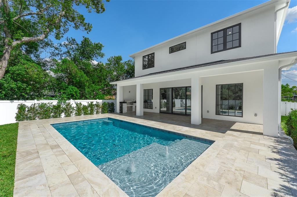 A modern two-story white house features a backyard swimming pool with a tanning ledge — 113 W EVANS STREET, ORLANDO, FL