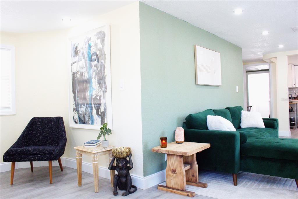 A living room features a green accent wall, a dark green sofa, and a black chair — 5260 8TH AVENUE N, ST PETERSBURG, FL